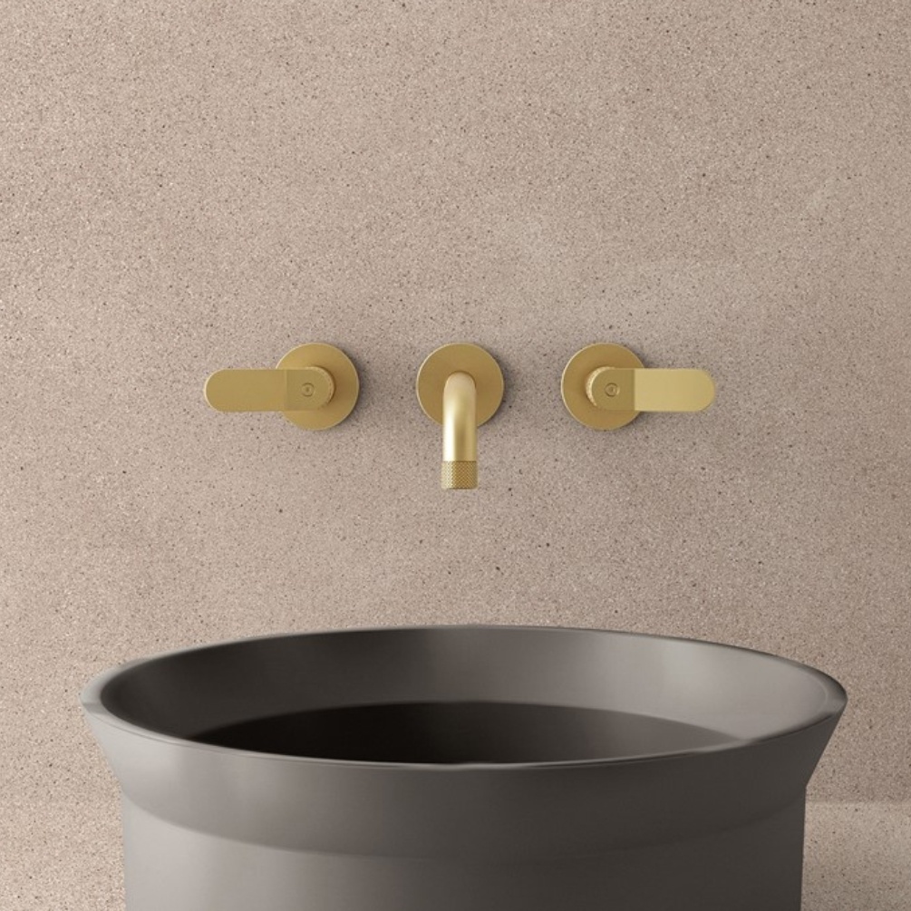 Lifestyle image of the Crosswater Calix Brushed Brass 3 Tap Hole Wall Mounted Mixer Tap installed above a countertop basin
